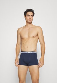 Navy blue cotton boxer briefs with a white elastic waistband featuring "GANT" logo. The design has a fitted shape for comfort and support.