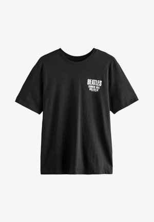 Zwarte katoenen t-shirt met de tekst "BEATLES" en "CARNEGIE HALL WOE. FEB. 12" in witte druk op de linkerkant van de borst.