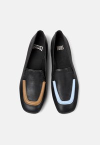 Scarpe slip-on in pelle nera con accenti a contrasto marroni e azzurri chiari sulla punta. L'interno presenta una fodera in tessuto nera e dettagli con logo.
