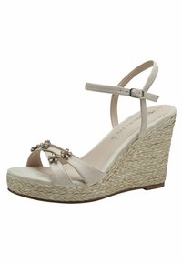 Μπεζ πλατφόρμες με τρεις διακοσμητικές ανθοσυνθέσεις, σουέντ λουριά και πλεκτό τακούνι εσπαντρίγια. Ρυθμιζόμενο λουράκι στον αστράγαλο για καλύτερη εφαρμογή.