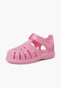 Roze plastic sandaal met een gesloten neus, open zijkanten, verstelbare band en gegoten ontwerp voor ventilatie. Gladde textuur en gevormde vorm.