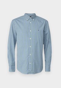 Camicia a maniche lunghe a quadretti blu e verdi con colletto a punta e bottoni bianchi. Presenta un piccolo logo sul petto.