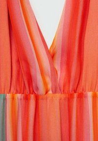 Robe fluide à col en V dans des teintes vibrantes d'orange et de rouge avec des rayures verticales subtiles, présentant un tissu léger et transparent et un détail de taille froncée.