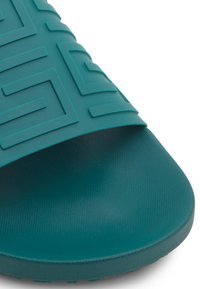 Infradito in gomma color teal con parte superiore testurizzata e motivo geometrico. Punta arrotondata e suola testurizzata, progettata per comfort e aderenza.