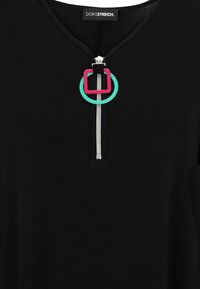 Black garment with a silver zipper and a zipper pull featuring overlapping turquoise circle and pink square shapes.