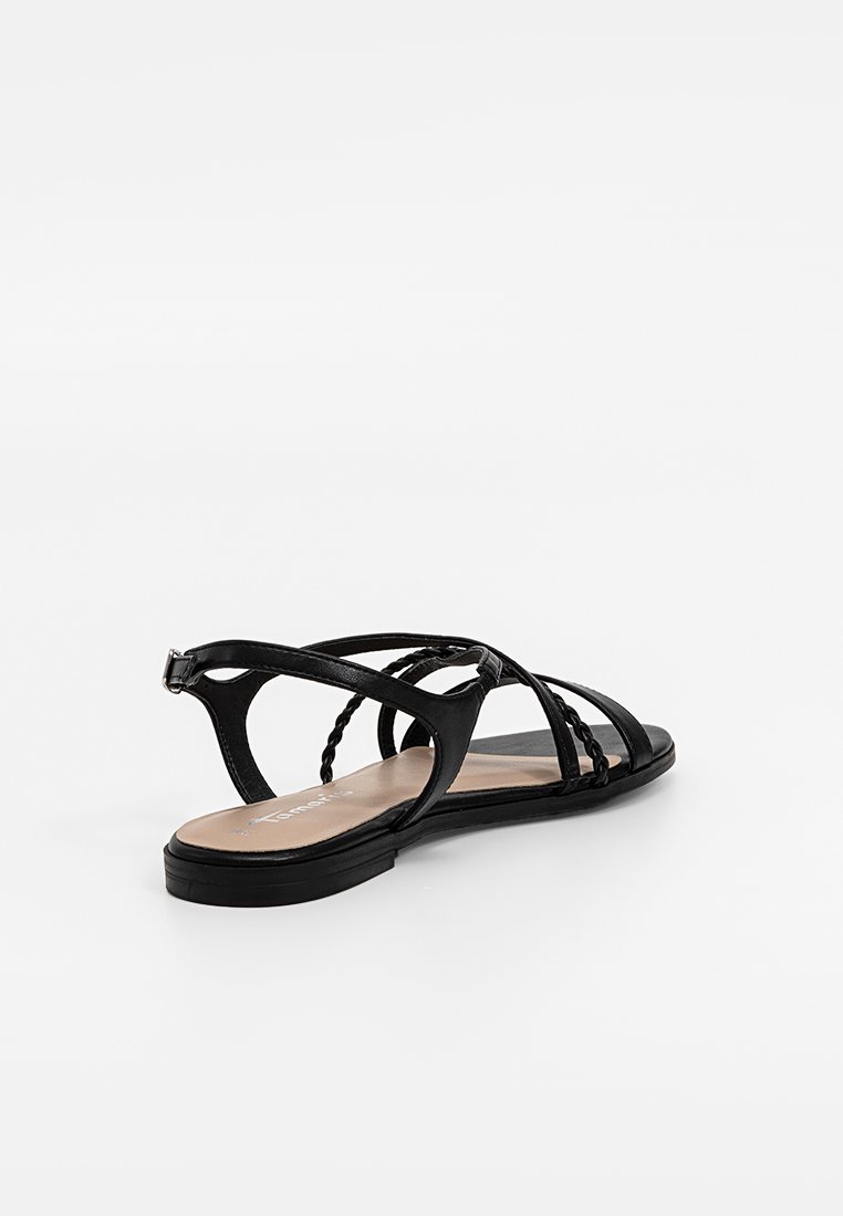 Sandales plates noires avec un design à lanières, dotées d'accents tressés et d'une semelle lisse. L'intérieur a une finition beige clair.