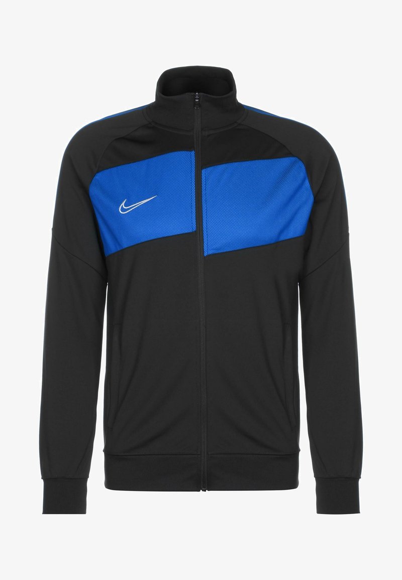 Veste zippée noire avec un panneau en maille bleu sur les épaules, présentant un logo Nike blanc sur la poitrine et deux poches latérales.