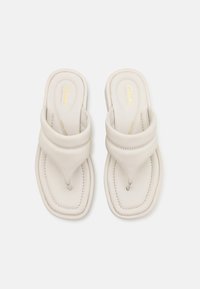 White leather sandals with a thong design, stitched accents, and a cushioned footbed, featuring a subtle logo on the insole.