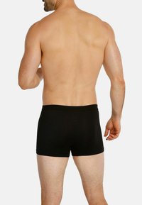 Black boxer briefs made of soft, stretch fabric, featuring a snug fit and elastic waistband. The design is seamless with clean edges.