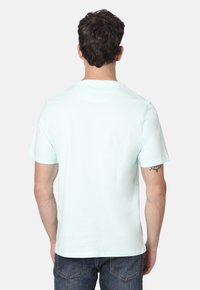 Camiseta de mangas cortas color verde menta con escote redondo. Material de algodón suave, corte relajado y parte trasera lisa sin adornos.