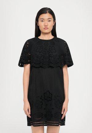 Black dress featuring intricate lace embroidery on the shoulders and hem. The fabric has a smooth texture with a relaxed fit.