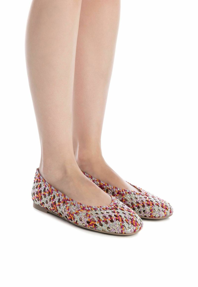 Bailarinas con un diseño textil trenzado y multicolor, que cuentan con una puntera redonda y una suela plana, exhibiendo una mezcla de tonos rosa, naranja y plata.