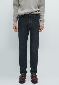 Jeans in denim scuro con taglio dritto, caratterizzati da un classico design a cinque tasche. Il materiale presenta una leggera texture con dettagli di sfumatura sottili.
