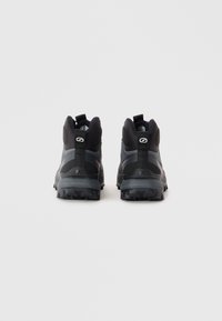 Schwarze und graue Wanderschuhe mit einer strukturierten Gummisohle, gepolstertem Knöchelunterstützung und verstärktem Absatz. Mit Logo auf der Rückseite.