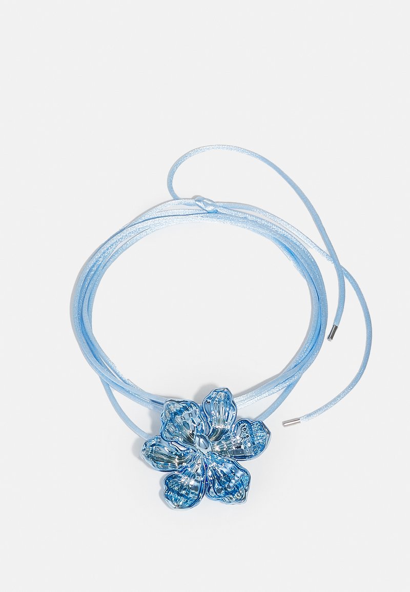Blå blomsterformet halskæde med en glansfuld overflade, der har intrikate kronblad detaljer, på en MATCHENDE blå satin snor med metalspidser.