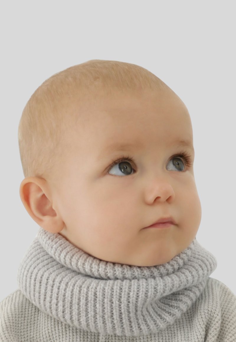 Pull à col roulé en tricot gris avec une texture côtelée, doté d'un col haut. Le sujet a la peau claire et des cheveux courts et clairs.