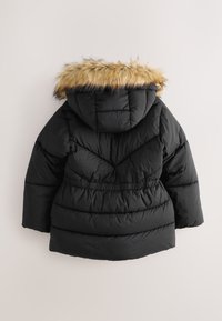 Černá prošívaná bunda s kapucí lemovanou kožešinou, má prošitou texturu a detail s elastickým pasem. Pohled zezadu ukazuje strukturovaný design.