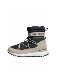 Černé a béžové Moon Boot s polstrovaným svrškem, elastickými šňůrkami a texturovanou podrážkou. Značka je umístěna na pásku a na boku.