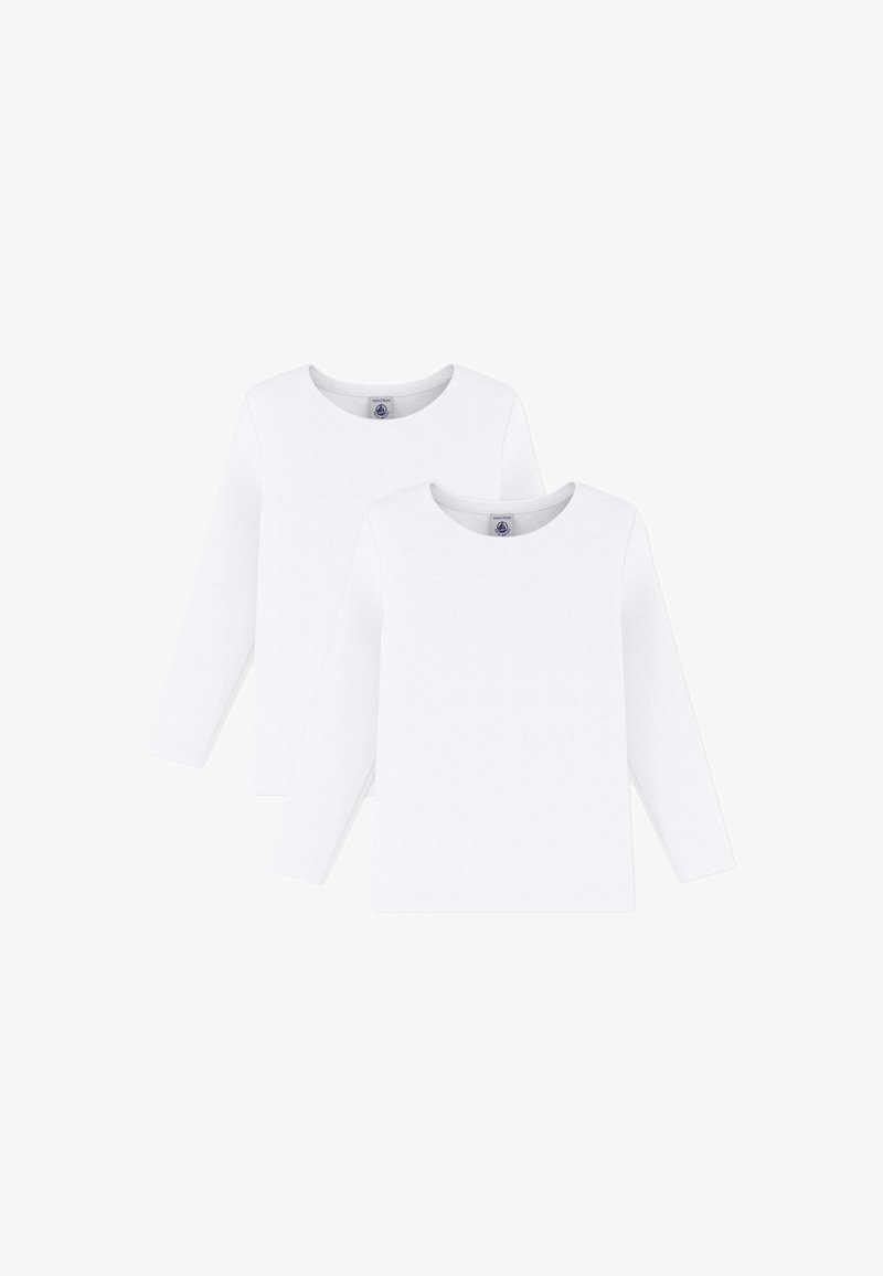 Dve jednoduché biele tričká s dlhým rukávom a okrúhlym výstrihom, rozložené na rovine so vzájomným prekrývaním, zobrazujúce prednú stranu a štítky na krku.