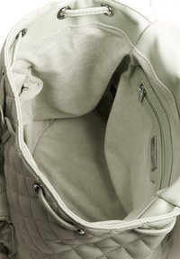 Borsa a tracolla verde chiaro trapuntata con interno in tessuto morbido, ferramenta in argento e tasca con zip. La borsa ha una chiusura con lacci.