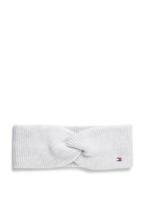 Bandeau blanc en tricot avec un nœud torsadé au centre et un petit logo rectangulaire rouge, blanc et bleu sur un côté.