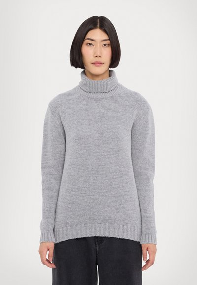Světle šedý rolák vyrobený z měkké pleteniny. Má žebrované manžety a lemování s volným střihem. Minimalistický design, bez vzorů.