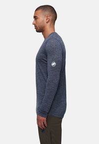 Herren Langarmhemd in melierter marineblau, aus weichem Material gefertigt, mit einem Logo auf dem linken Ärmel und einer taillierten Passform.