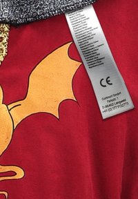 Red fabric featuring a yellow bat graphic and gold accents. Includes a care label with text in multiple languages and CE mark.