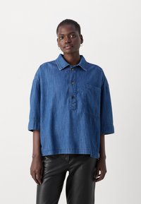 Blaues Denim-Hemd mit Kragen, Knopfverschluss vorne, kurzen Ärmeln und einer Brusttasche, in entspannter Passform und leichter Textur.