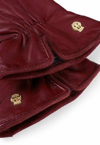 Burgunderrote Lederhandschuhe mit einer weichen Textur, verziert mit goldenen Totenschädel-Akzenten und gestickten Details. Innenfutter für zusätzlichen Komfort.