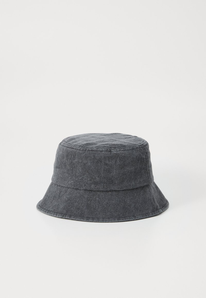 Sombrero bucket de denim gris con ala ancha, que presenta un sutil detalle de costura. Textura suave y forma cilíndrica.