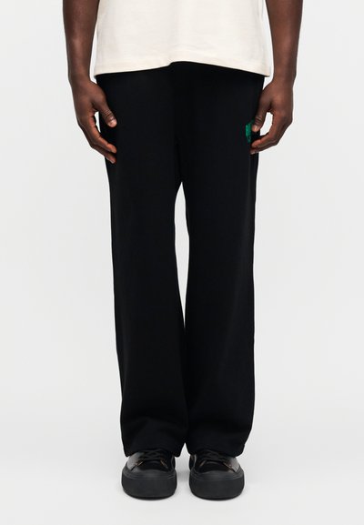 Μαύρο παντελόνι φαρδύ με ελαστική μέση, από βαμβακερό μείγμα, με μικρό πράσινο κεντημένο λογότυπο στην αριστερή τσέπη, με μαλακή υφή και άνετη εφαρμογή.
