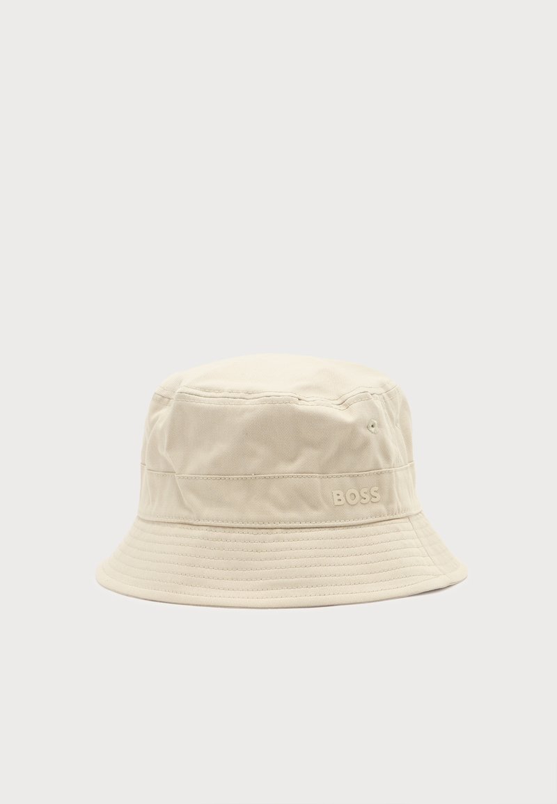 Chapeau bob en tissu beige avec détails cousus et petit logo "BOSS" sur le côté, sur un fond clair uni.