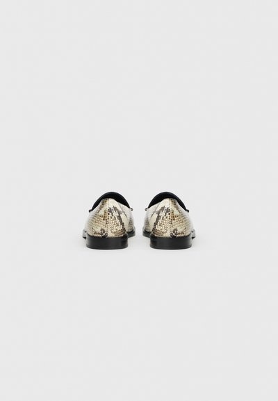Fekete talpú kígyóbőr mintás cipők, kerek orral és sima textúrával, csúszásmentes viseletre tervezve.