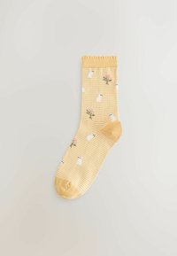 Gele sokken met strepen en bloemen- en berenpatronen, gemaakt van zacht materiaal met een geribbelde boord en verstevigde teen.