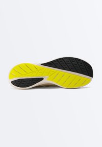 Semelle de chaussure avec motifs de bande de roulement en caoutchouc noir et jaune conçus pour l'adhérence et la durabilité sur un fond clair.