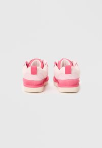 Sneakers rosa e bianchi con tomaia in rete testurizzata, collo imbottito e suola in gomma rosa a contrasto. Presentano doppie linguette di traino sui talloni.
