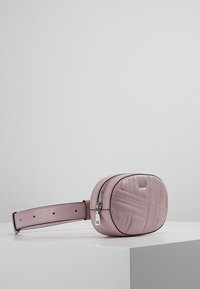 Pink faux leather belt bag with diagonal stitching, oval shape, silver-tone zipper, and adjustable strap. Clean design and smooth texture.