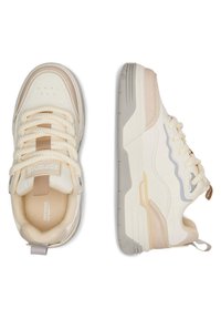 Sneakers w kolorze kremowym i beżowym, charakteryzujące się mieszanym wzornictwem, grubymi sznurowadłami, teksturowaną podeszwą oraz subtelnym falistym wzorem po bokach.