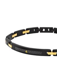 Schwarzes Armband mit goldenen Akzenten, das ein glattes, segmentiertes Design und eine zentrale Einlage aus Carbonfaser aufweist. Strapazierfähiges Material mit einer eleganten Oberflächenstruktur.