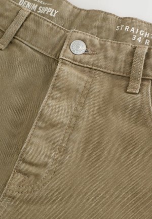 Beżowe spodnie proste z fakturowanej tkaniny, z zapięciem na guzik z przodu i przeszyciami na pasku.