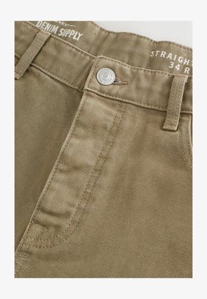 Smėlio spalvos tiesaus kirpimo kelnės su tekstūruota paviršiumi, turinčios priekinį mygtuką ir siuvinėjimą ant juosmens.