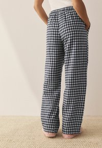 Námořnické a světle modré kostkované pyžamové kalhoty s elastickým pasem a bočními kapsami, vyrobené z měkké, lehké tkaniny.