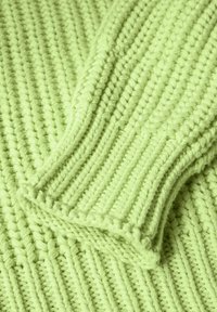 Limonengrüner gestrickter Pullover mit geripptem Material, aus dicker, weicher Wolle und aufgerollten Ärmelabschlüssen. Akzentuiert mit kontrastierenden Linien.