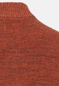 Strickpullover in einem warmen rötlich-orangefarbenen Farbton, mit einem hohen Kragen und einem dichten, gleichmäßig verteilten Muster.