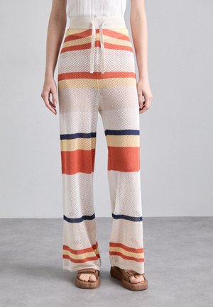 Brede, gebreide mesh broeken met verticale rode, gele en marineblauwe strepen. Voorzien van een elastische tailleband met trekkoord en een gestructureerde, ademende stof.