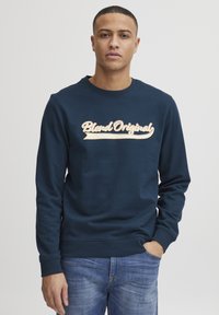 Marineblauw sweatshirt van katoen met een ronde hals. Voorzien van een groot, lichtgekleurde "Blend Original" logo in cursieve stijl op de voorkant.