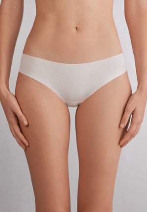 Naadloze witte bikiniondergoed met een gladde textuur, een gematigd hoge taille, smalle elastische tailleband en minimale bedekking. Geen zichtbare naden.