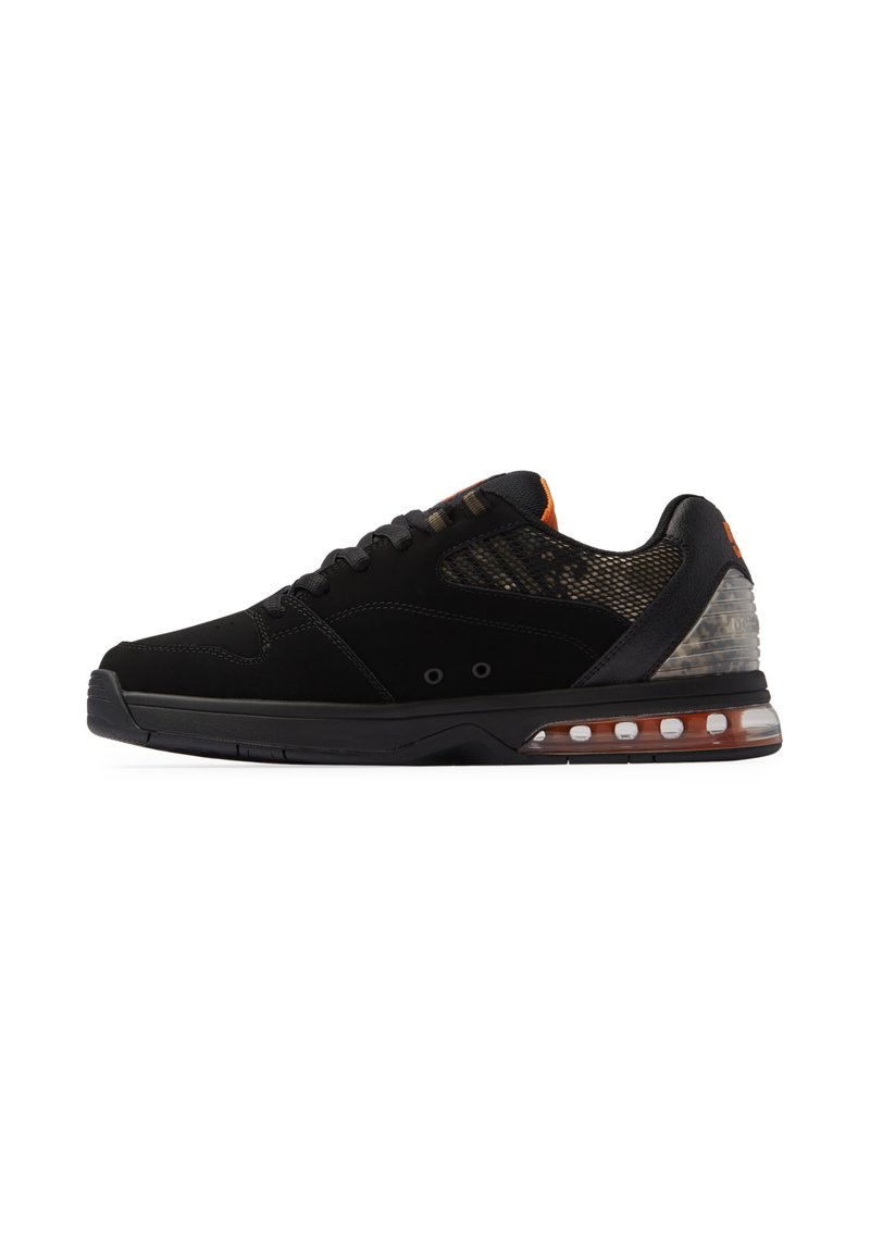 Zapatilla deportiva negra con un panel de malla, acento naranja y un talón de amortiguación de aire transparente. Presenta un diseño elegante y materiales texturizados.