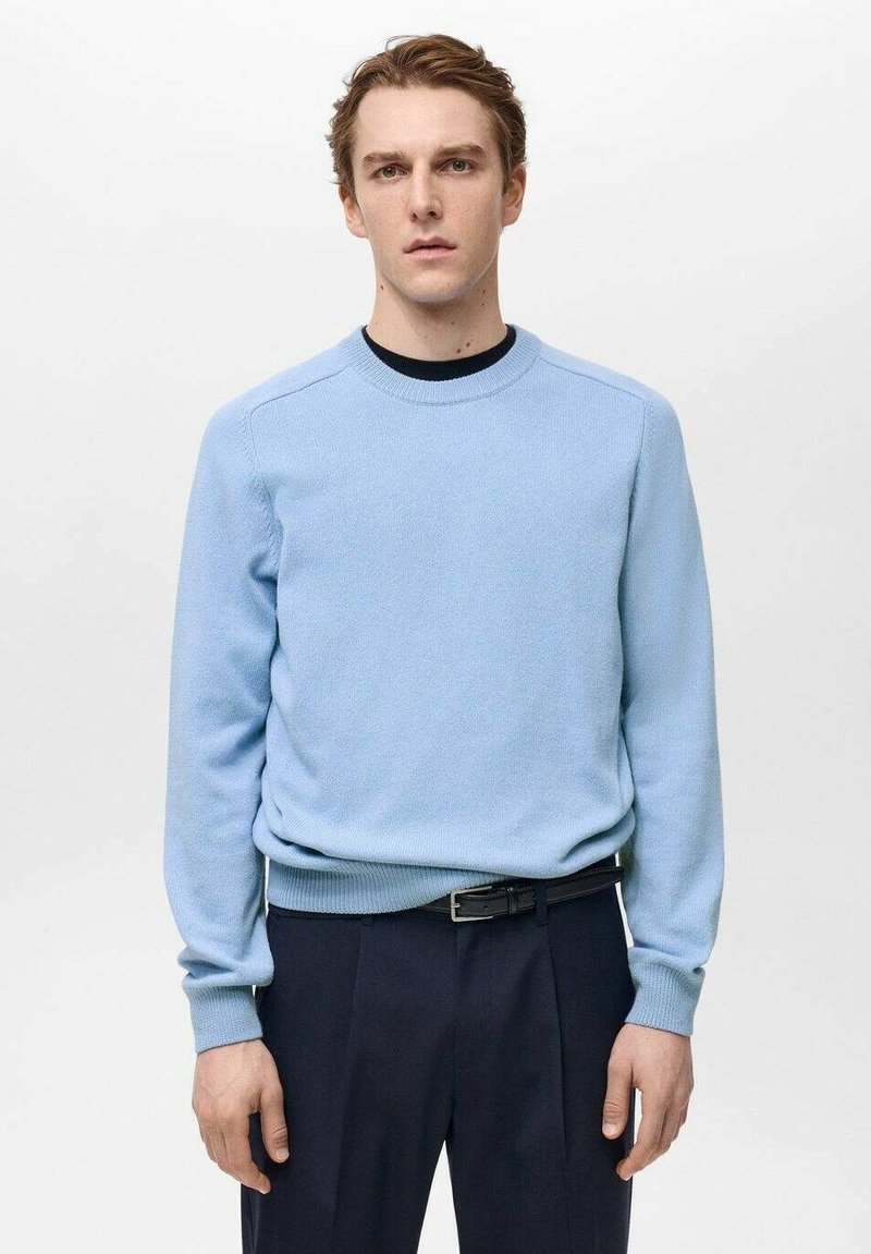 Pulover bleu deschis, realizat dintr-un material tricotat moale, cu guler rotund și mansete cu dungi. Asortat cu pantaloni închiși la culoare, creat pentru un aspect casual.
